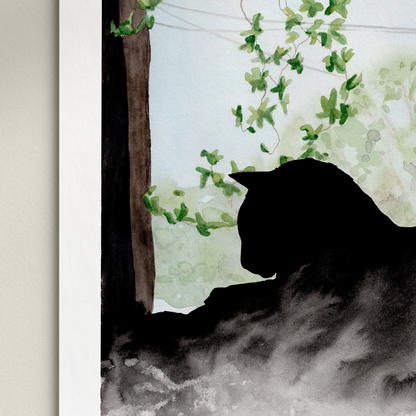 Framed artwork of a silhouette of a cat in a misty forest scene on a white wall.