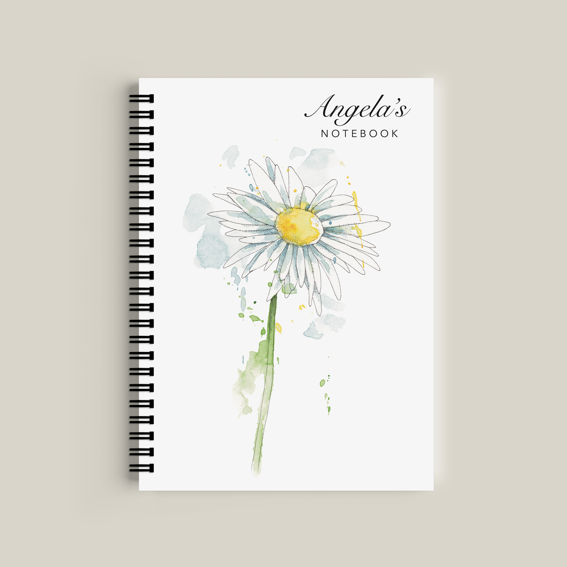 Notebook with a daisy design and 'Angela's Notebook' text on a beige background